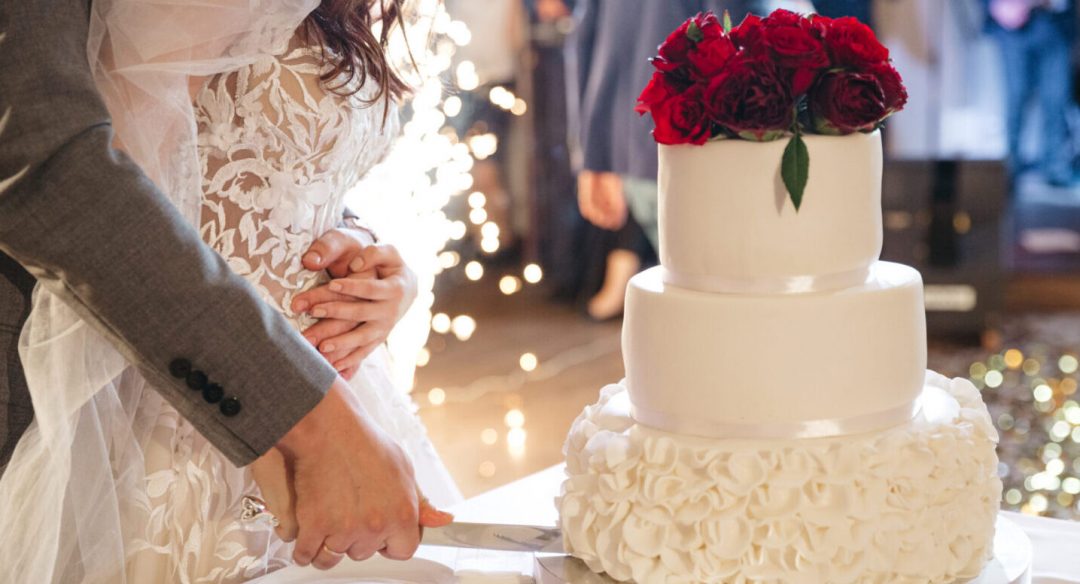 Happy bride and groom cut a wedding cake